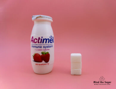 One bottle of Actimel contains 12g of sugar, equivalent to 3 sugar cubes A photo of a bottle of Actimel with 3 cubes of sugar