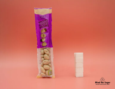 One bag of M&S Yogurt Coated Raisins contains 19,9g of sugar, equivalent to 5 sugar cubes A photo of M&S Yogurt Coated Raisins bag with 5 cubes of sugar.