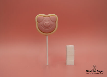 One lolly of M&S Percy Pig decorated milk chocolate lolly  contains 15,3g of sugar, equivalent to 3,8 sugar cubes A photo of M&S Percy Pig decorated milk chocolate lolly with 3.8 cubes of sugar.